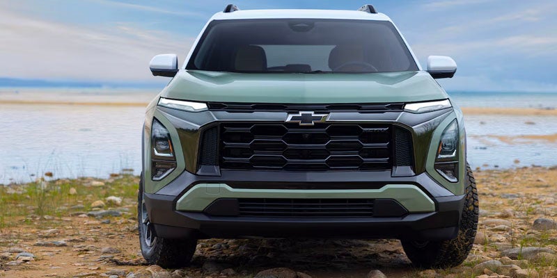 A green Equinox parked near lake on land front view