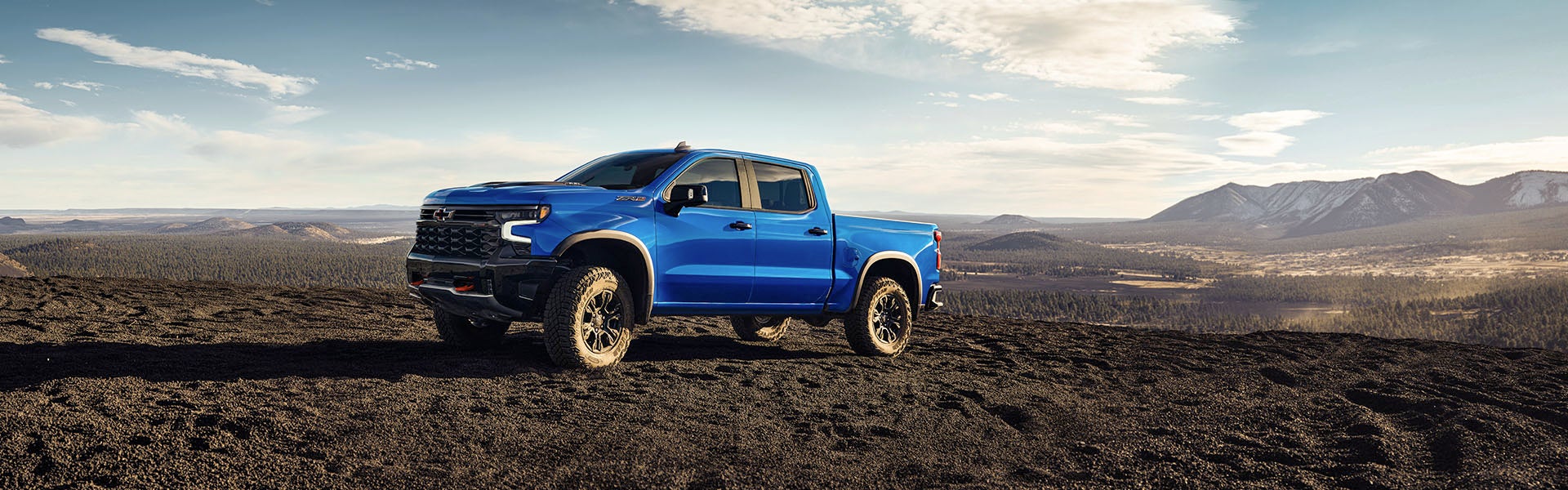 Blue Silverado driving in soil
