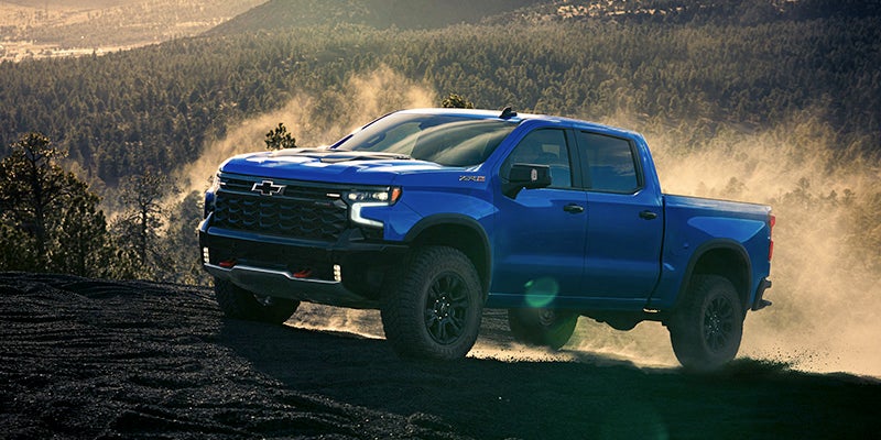 A blue truck climbing on soils hills