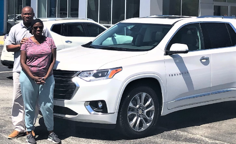 Couple in front of white Tahoe SUV