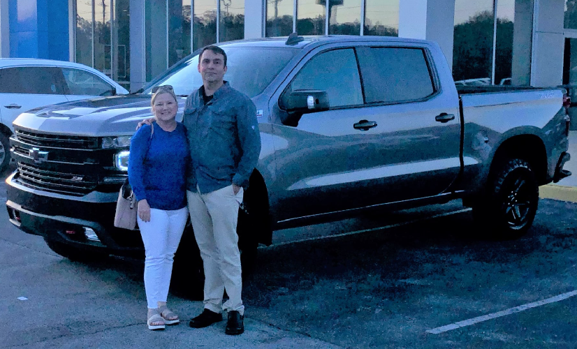 Couple in front of truck at Glynn Smith Chevrolet Buick GMC