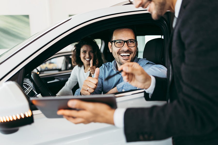 couple siting inside a showroom car